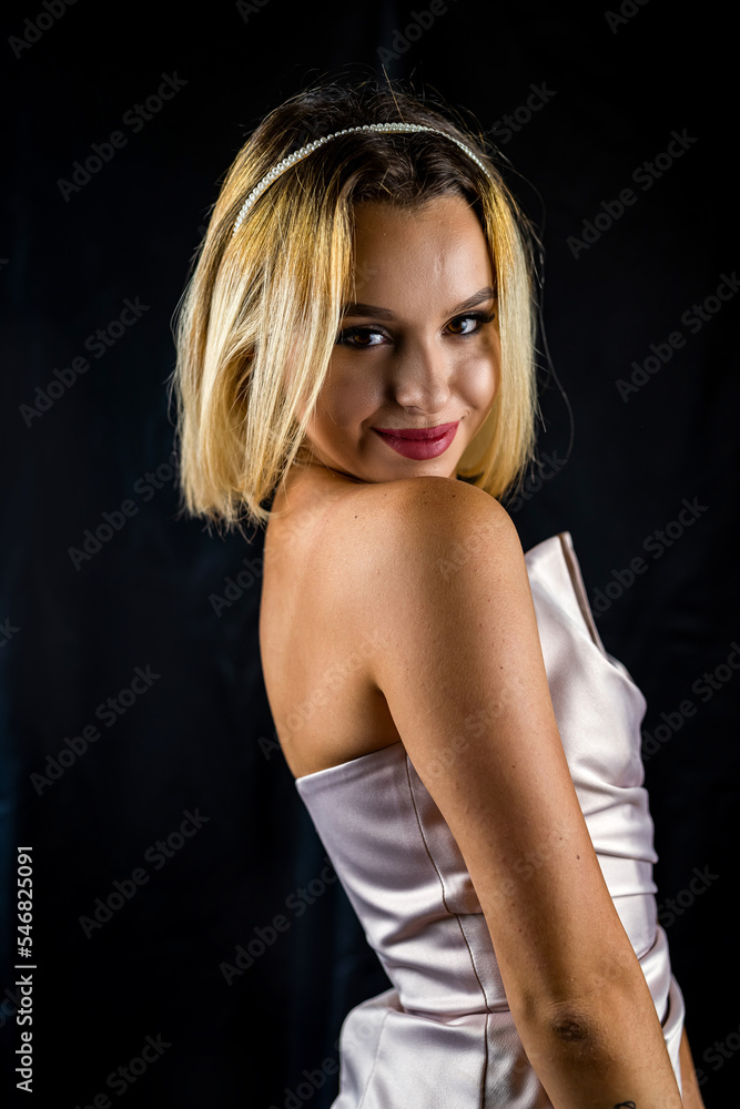 Naklejka premium Beauty portrait of a gorgeous young woman in a silk robe smiling seductively.