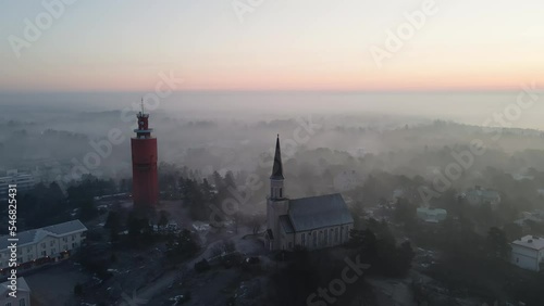 Aerial view around the church and water tower, foggy, spring morning in Hanko, Finland - orbit, drone shot photo