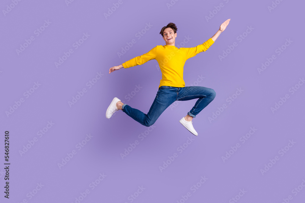 Full size photo of crazy carefree guy jump high hands aside isolated bright studio shot background