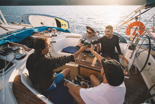Group of friends enjoy sailing with beer
