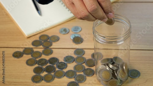 4K-UHD Slow motion of man hand putting coins in money box for account save money. Planning step up, saving money for future plan, retirement fund. Business investment-finance.