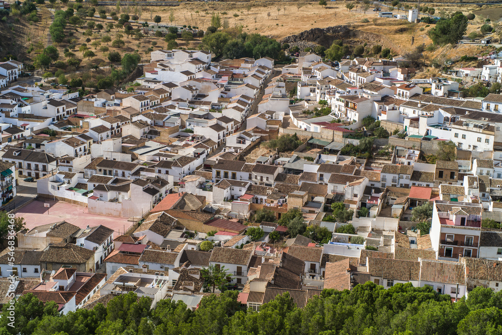 the city of Antequera. tight buildings, white houses, monuments, churches view from the castle hill. Peña de los Enamorados hills and rock in the background