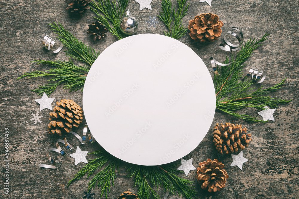 Fototapeta premium Flat lay Christmas composition. Round Paper blank, pine tree branches, christmas decorations on Colored background. Top view, copy space for text