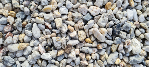 Natural gravel texture. Multi colored pebbles. Beautiful background. Vacation, holiday, beach mood.