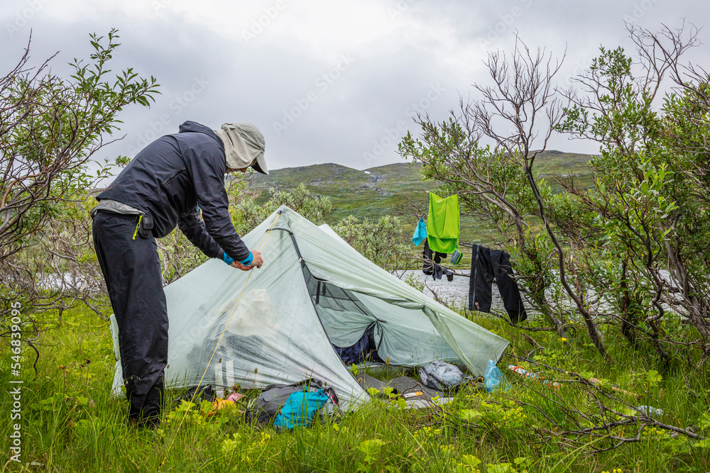 Man by tent while camping Man by tent while camping