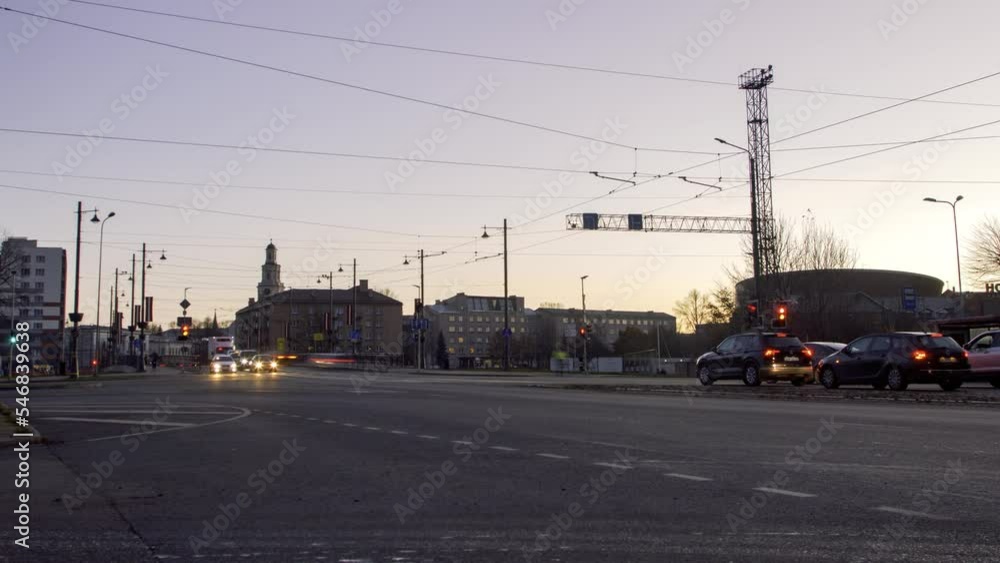 Timelapse of city rush hour traffic over the Liepaja tram bridge, city landscape after the sunset, traffic light streaks, fast moving trams, low wide shot Timelapse of city rush hour traffic over the Liepaja tram bridge, city landscape after the sunset, traffic light streaks, fast moving trams, low wide shot