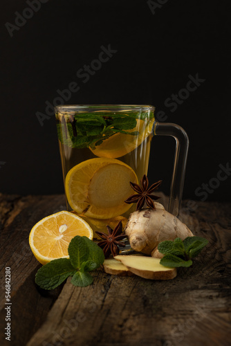 Tea with lemon and cinnamon. Ginger tea with lemon and spices on a wooden table.