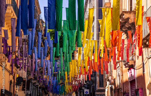 european street, decorated with hanged colorful ribbons in lgbt flag colors, city art with symbol of peace photo