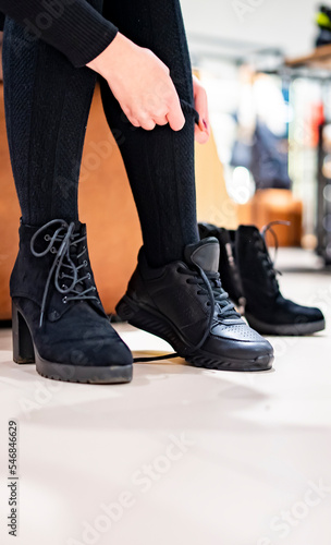 Woman trying new black shoes sitting in a shop