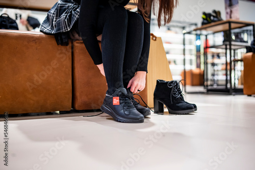 Woman trying new black shoes sitting in a shop © pavel siamionov