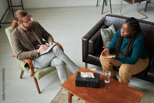 Фотография High angle view of psychotherapist discussing problems with patient during psych