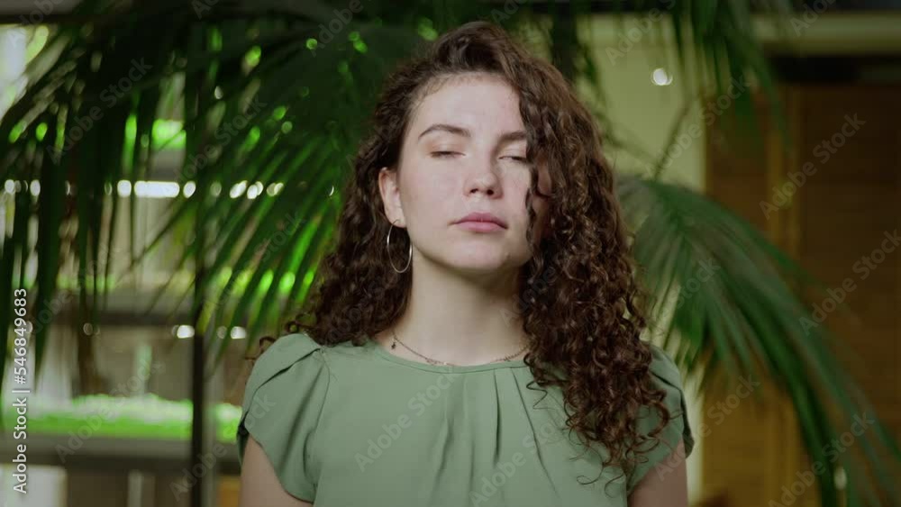 Close-up of a young woman with brown curly hair looking into the camera. Portrait of a girl Close-up of a young woman with brown curly hair looking into the camera. Portrait of a girl