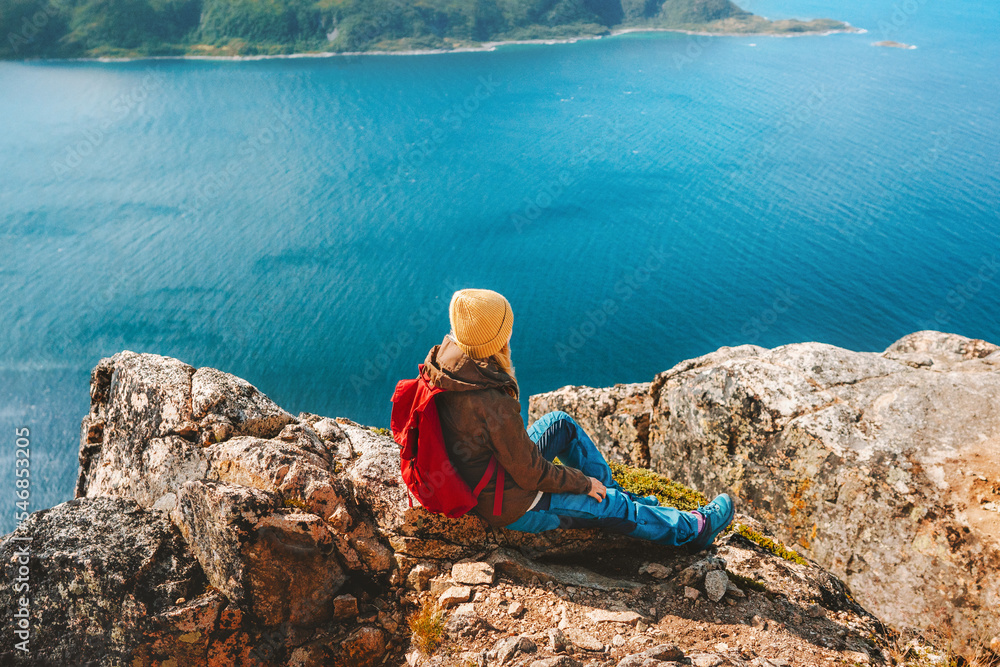 Female traveler with backpack enjoying aerial fjord view travel hiking outdoor in Norway active healthy lifestyle vacations trip eco tourism