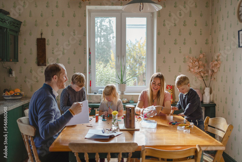 Happy young family at dining table at home together  