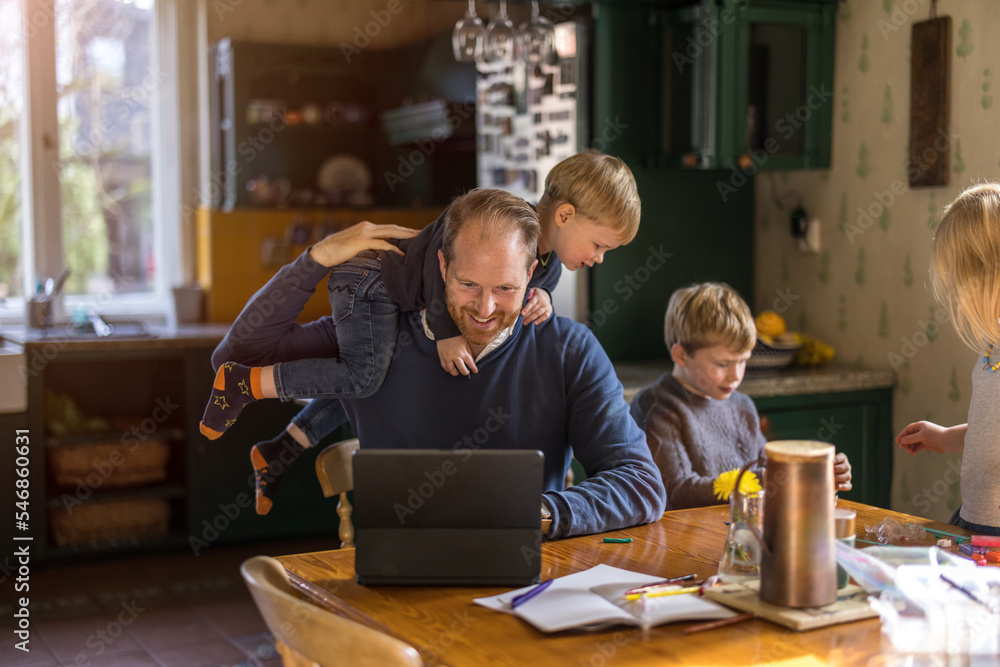 Fototapeta premium Dad using tablet at home with kids 