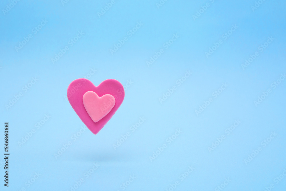 Floating soft pink hearts made of vivid air plasticine, a colorful air mass for children's art on pastel buel background. Expression of love, Valentine's Day. Floating soft pink hearts made of vivid air plasticine, a colorful air mass for children's art on pastel buel background. Expression of love, Valentine's Day.