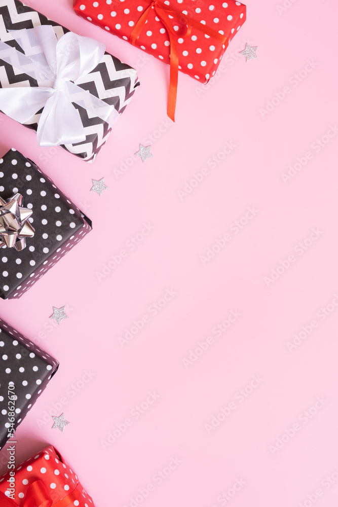 Christmas presents flat lay on a pink background. Top view xmas gifts with decorations