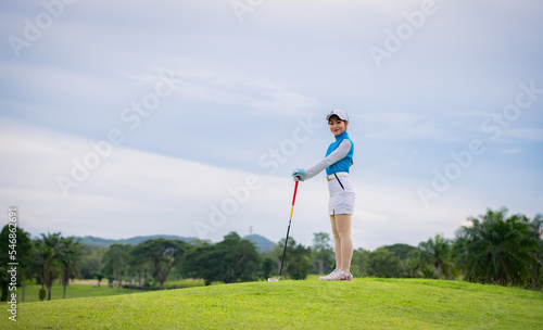 Woman golfer check line for putting golf ball on green grass ,player crouching and study the green before putting shot.