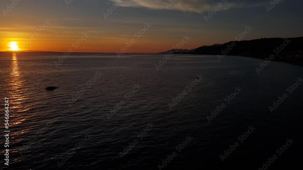 Sunset on the horizon over the Mediterranean Sea viewed from a sandy beach Sunset on the horizon over the Mediterranean Sea viewed from a sandy beach
