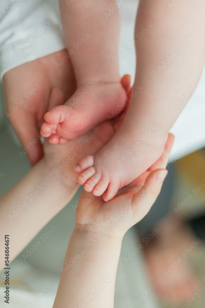 Close portrait of a little cute dark-haired newborn girl in a white suit in the arms of a young mother. Motherhood. Parent. Healthy sleep. Close portrait of a little cute dark-haired newborn girl in a white suit in the arms of a young mother. Motherhood. Parent. Healthy sleep.