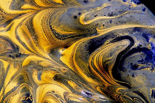 Pinturas de acrìlico en agua y aceite flotando en la superficie forma un diseño con movimiento abstracto en olas y ondas multicolor para fondos texturizados