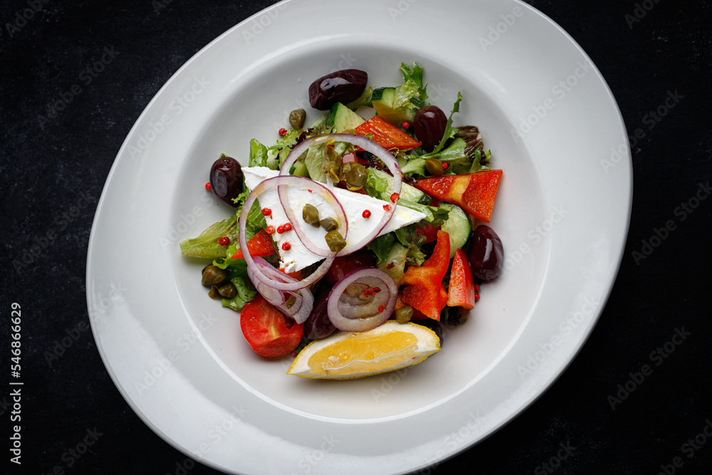Greek salad with vegetables and cheese on a dark background Greek salad with vegetables and cheese on a dark background