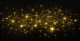 The dust sparks and golden stars shine with special light on a black transparent background. Golden shiny light effect.