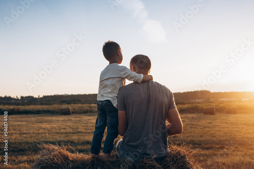 Father and son playing in the park at the sunset time. Family, trust, protecting, care, parenting, summer vacation concept
