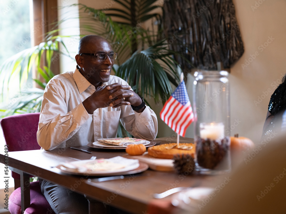 Smiling man sitting at Thanksgiving table Smiling man sitting at Thanksgiving table