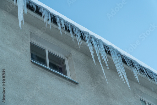 Huge and dangerous icicles hanging from the roof of the building