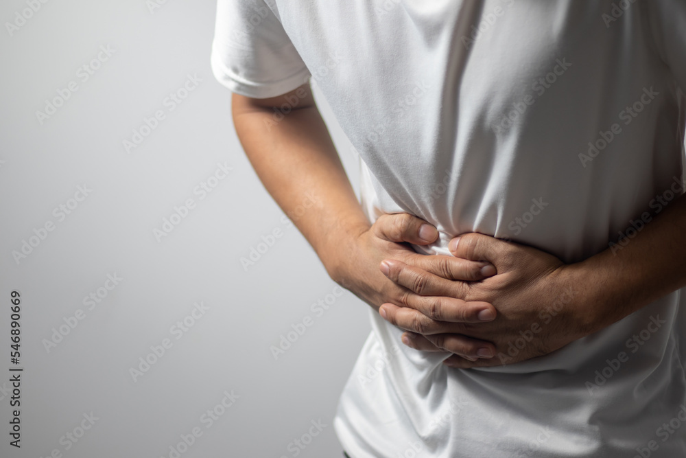 Naklejka premium man having abdominal pain on white background