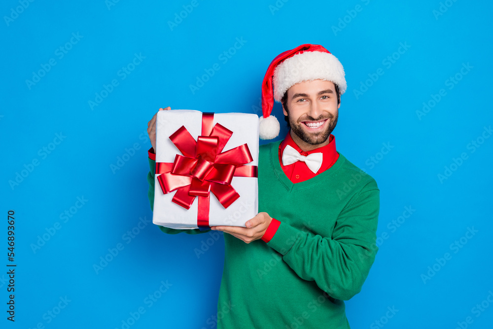 Portrait of cheerful positive man hands hold giftbox toothy smile isolated on blue color background Portrait of cheerful positive man hands hold giftbox toothy smile isolated on blue color background