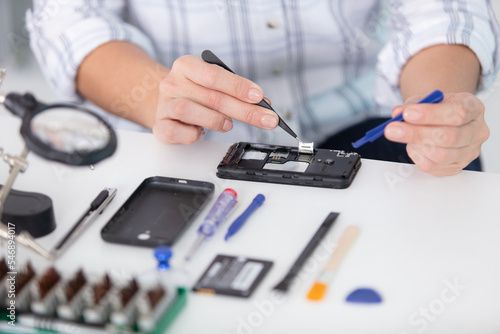 technician carefully examines the integrity of a phone
