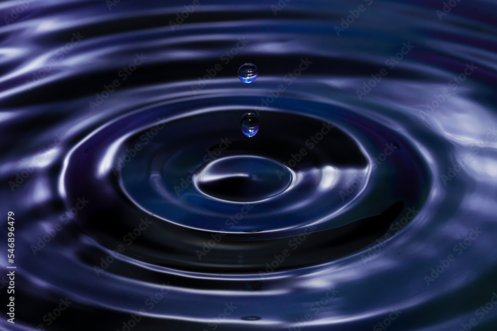 Circles on the water from a fallen drop of water. Purple background. Circles on the water from a fallen drop of water. Purple background.