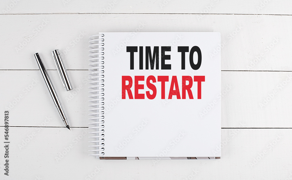 TIME TO RESTART text written on notebook on the wooden background TIME TO RESTART text written on notebook on the wooden background