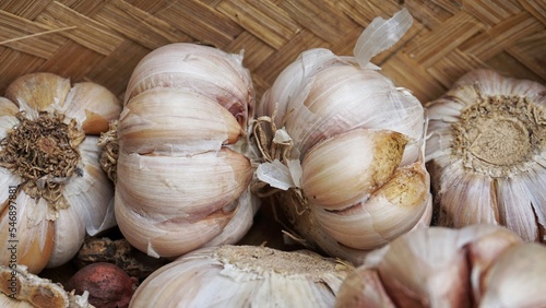 Whole garlic bulbs in a container made of bamboo.