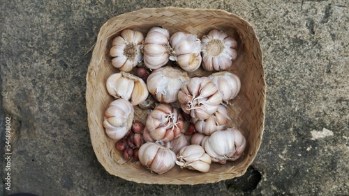 Whole garlic bulbs in a container made of bamboo.