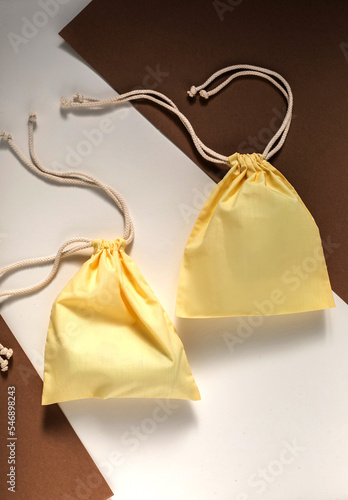 atwo yellow lace-up bag lies on a white-brown background photo