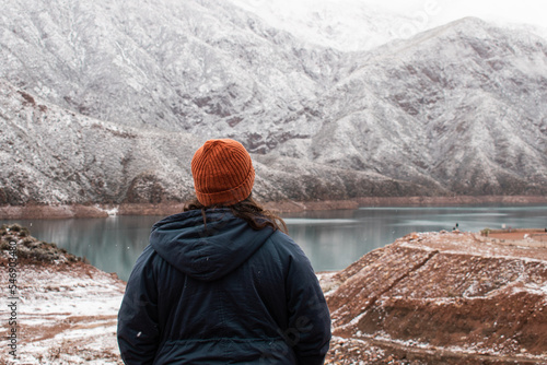 Woman admiring the snow-capped mountains of the Potrerillos dam, Mendoza.