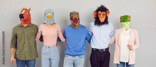 Foto Crazy funny team of happy people wearing strange eccentric Halloween carnival animal masks standing in row and hugging each other