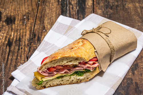 Fotografie Panini sandwich with ham, crispy salad and vegetables