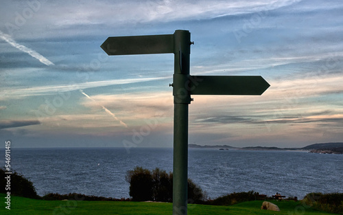 Road sign on the background of the sea landscape in the late evening