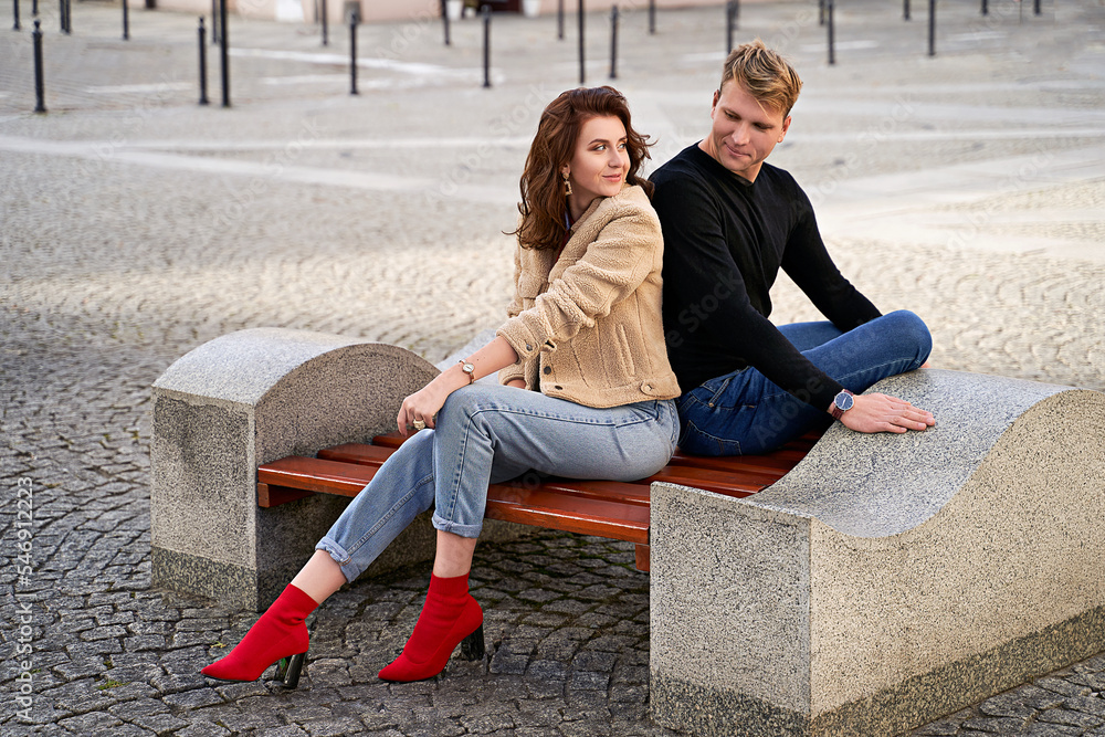 Beautiful young couple sitting on a bench in the city during a romantic date