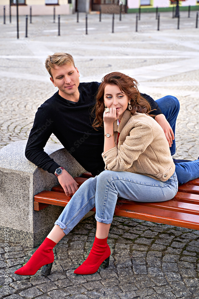 Beautiful young couple sitting on a bench in the city during a romantic date