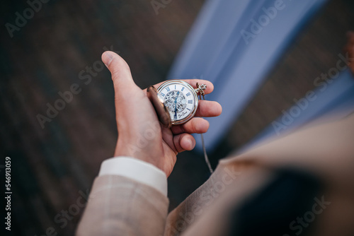 Ein Mann schaut auf eine taschenuhr photo