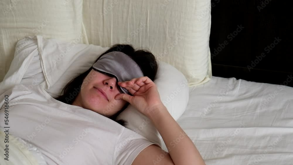 woman waking up peeking from the sleeping mask woman waking up peeking from the sleeping mask