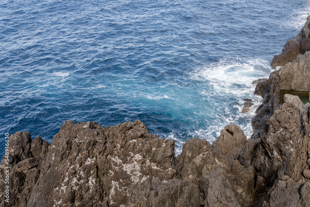 ocean waters gushing on volcanic cliffs at Porto Moniz, Madeira