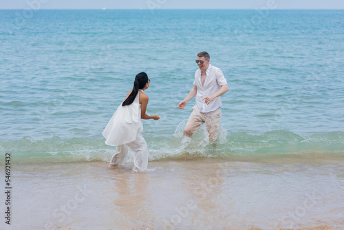 Happy wedding couple running by the beach. Romantic feelings and vibes.