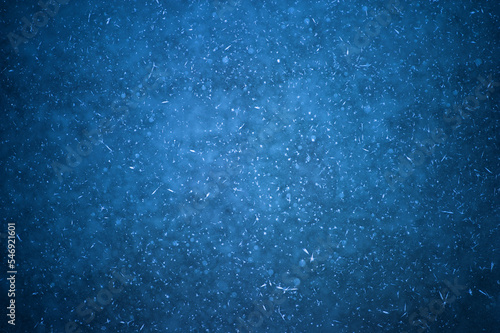 Dark blue ice with frozen bubbles with the texture of white frost. Background design concept