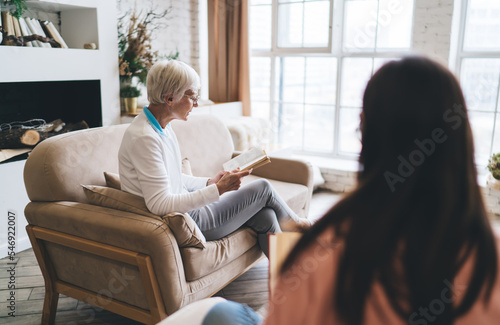 Senior woman reading book in living room
